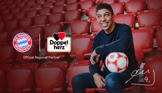 Homem sorridente sentando-se em uma arquibancada vazia, segurando uma bola de futebol. Há logos do FC Bayern München e da Doppelherz ao lado, com a inscrição "Official Regional Partner". Fundo vermelho.